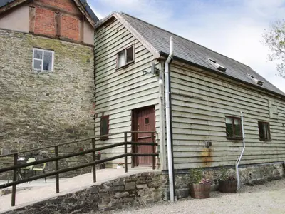 a barn with a red door next to a building at Broughton Stables in Montgomery