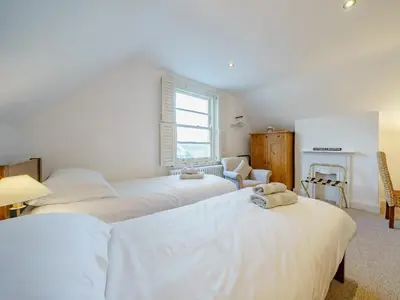 a bedroom with three beds with white sheets at Ystwyth House in Borth