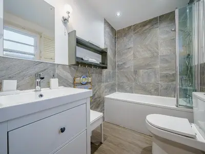 a bathroom with a sink and a toilet and a tub at Ystwyth House in Borth