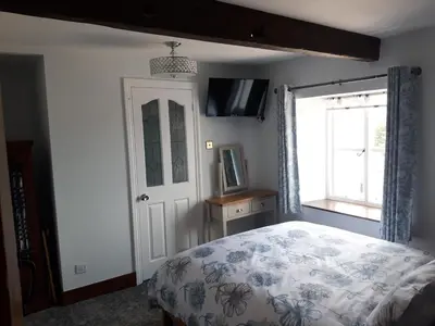a bedroom with a bed and a window at Upper Eyton Farmhouse B&B in Shrewsbury