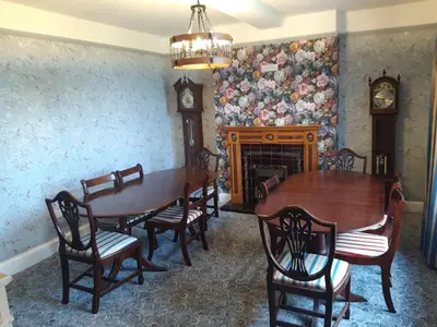 a dining room with a table and chairs and a fireplace at Upper Eyton Farmhouse B&B in Shrewsbury