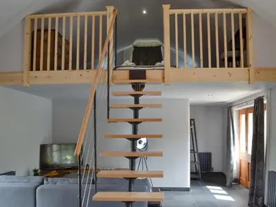 a spiral staircase in a living room with a couch at Caffi Sali - Weluk143 in Blaenpenal