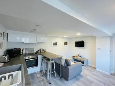 a kitchen and living room with a table and a couch at 10 Bromleys Court in Church Stretton