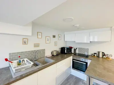 a kitchen with white cabinets and a sink at 10 Bromleys Court in Church Stretton