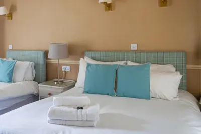 a bedroom with a large bed with towels on it at Ye Old Boote Inn in Whittington