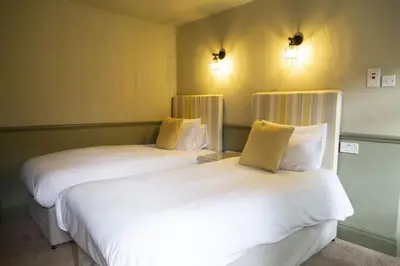 two beds sitting next to each other in a room at Ye Old Boote Inn in Whittington