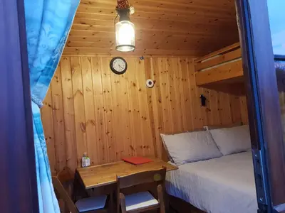 a bedroom with a bed and a table and a clock at Cozy Cabin Retreat - Sleeps 2 & a Child in Craven Arms