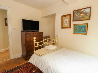 a bedroom with a bed and a flat screen tv at Cwmalis Hall in Llangollen