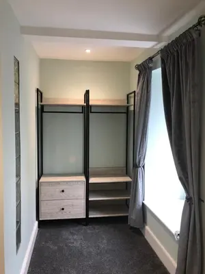 a walk in closet with glass shelves and a window at Mount Street House in Brecon