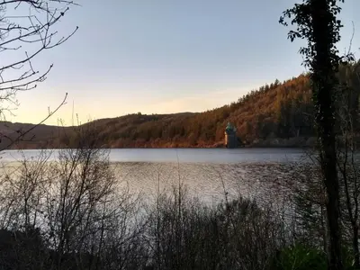 a lake with a lighthouse in the middle of it at Lake Vyrnwy Luxury Pod in Llanwddyn