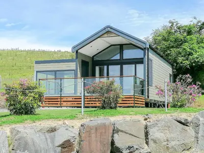 a small house with a large window on a field at Lake Vyrnwy Luxury Pod in Llanwddyn