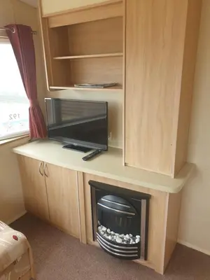 a living room with a fireplace and a tv at Hill View caravans in Aberystwyth