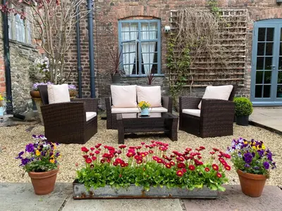 a patio with chairs and flowers in front of a building at The Old Stores in Montgomery