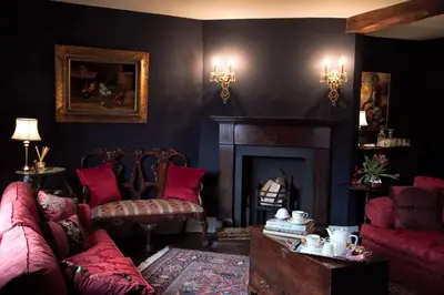 a living room with red furniture and a fireplace at The Old Stores in Montgomery