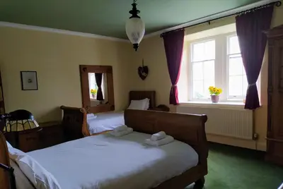 a bedroom with two beds and a window at Cae'r Blaidd Country House in Ffestiniog
