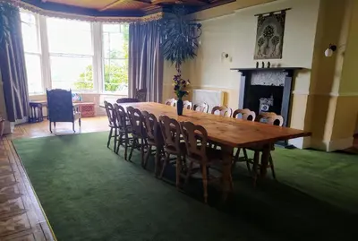 a dining room with a wooden table and chairs at Cae'r Blaidd Country House in Ffestiniog