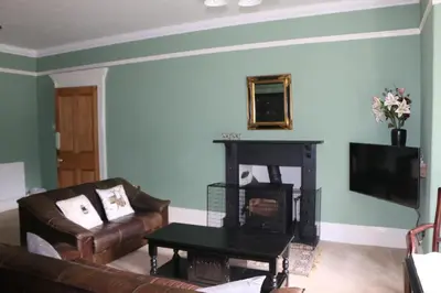 a living room with a couch and a fireplace at Cae'r Blaidd Country House in Ffestiniog