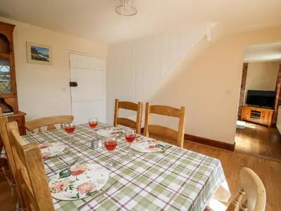 a dining room table with glasses of wine on it at Green Cottage in Rhayader