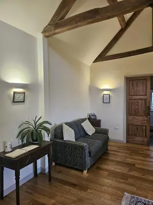 a living room with a couch and a table at Pandy Barn Berriew in Welshpool