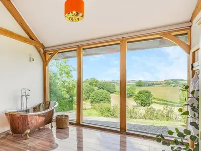 a bathroom with a tub and a large window at Oak View in Highgate