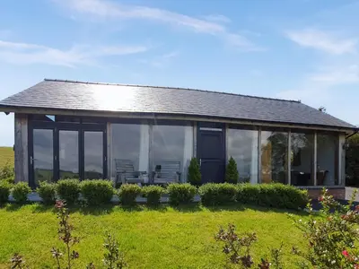 a large house with glass windows on a field at Oak View in Highgate