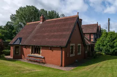 a brick house with a bench in a yard at Finest Retreats - The Grove Annexe in Craven Arms
