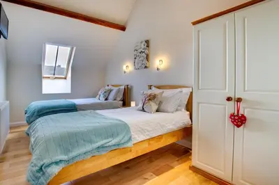 two beds in a bedroom with white walls and wood floors at 3 Bed in Tywyn oc-bow170 in Tywyn