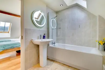 a bathroom with a sink and a bath tub and a mirror at 3 Bed in Tywyn oc-bow170 in Tywyn