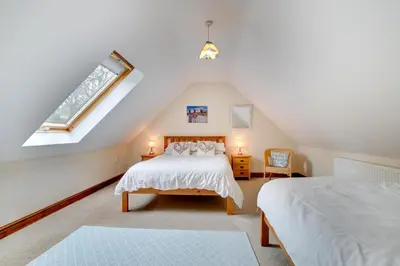 a attic bedroom with two beds and a window at 3 Bed in Bala oc-bow162 in Bala