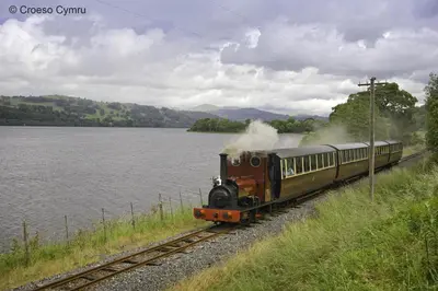 a train traveling down the tracks next to a body of water at 3 Bed in Bala oc-bow162 in Bala