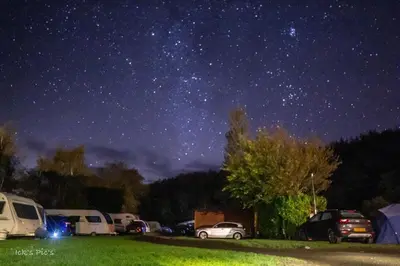 a starry night with cars parked in a parking lot at Torrent Walk Glamping Huts in the Heart of Snowdonia in Dolgellau