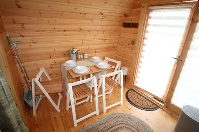 a dining room with a table in a log cabin at Torrent Walk Glamping Huts in the Heart of Snowdonia in Dolgellau