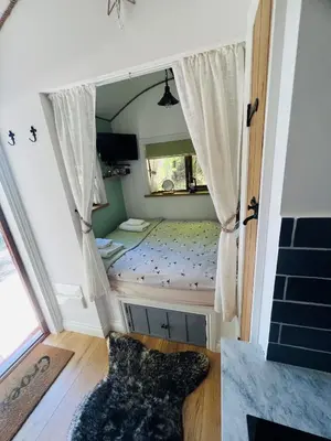 a small bed in a room with a window at Torrent Walk Glamping Huts in the Heart of Snowdonia in Dolgellau