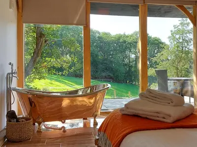a bathroom with a tub and a large window at The Hideaway in Highgate