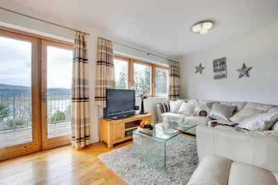 a living room with a white couch and a television at The Old Stables Aberdyfi apartment 6 in Aberdyfi