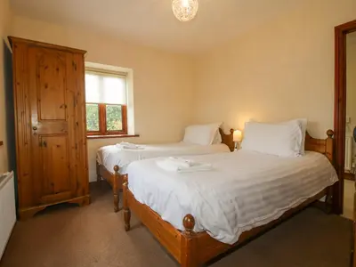 a bedroom with two beds and a window at The Onibury in Craven Arms