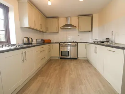 a kitchen with white cabinets and stainless steel appliances at The Walton in Craven Arms