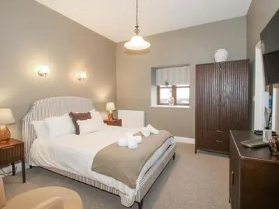 a bedroom with a bed with a dresser and a desk at The Park in Craven Arms
