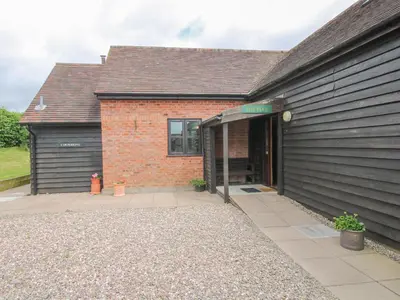 a brick building with a door open to a courtyard at The Park in Craven Arms