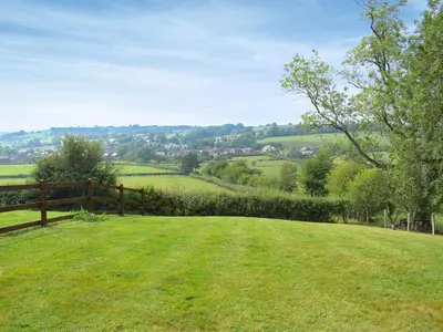 a field of green grass with a wooden fence at Talog Barn-Uk31366 in Tregynon