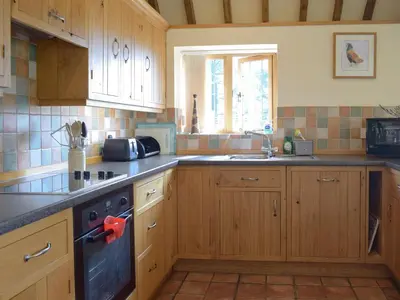 a kitchen with wooden cabinets and a stove top oven at Talog Barn-Uk31366 in Tregynon