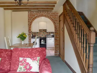 a living room with a red couch and a staircase at Y Bwthyn-Uk31367 in Tregynon