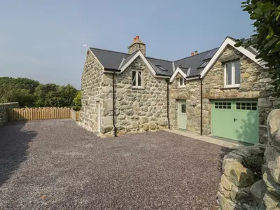 a stone house with a driveway and a garage at Tyn Ffynnon in Dyffryn