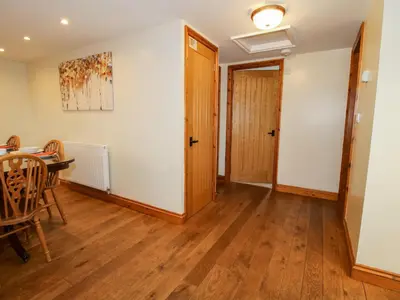 a living room with a table and a door at Norton Cottage in Craven Arms