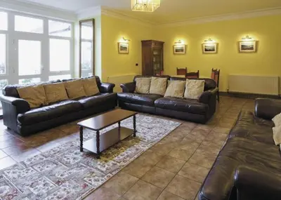 a living room with leather couches and a coffee table at Lovely Large home 10 Minute Walk to Barmouth Beach in Barmouth