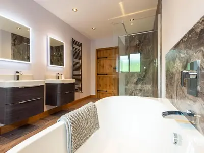 a bathroom with a tub and two sinks and a shower at Granar in Derwen