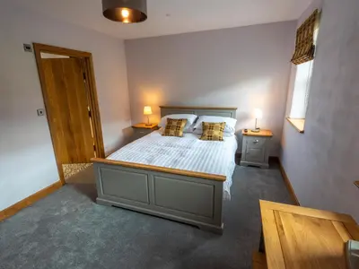 a bedroom with a bed with two lamps on it at Granar in Derwen