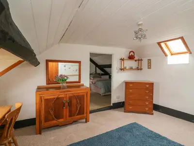 a room with a dresser and a mirror and a bedroom at Caerau Farm House in Llanidloes