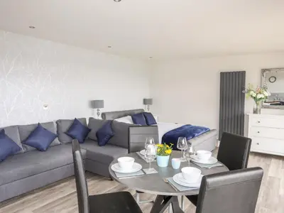 a living room with a couch and a table with blue pillows at Meadow Lodge in Corwen