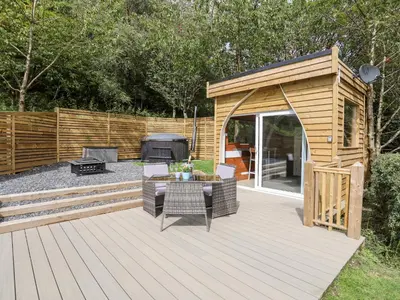 a wooden deck with a gazebo and a grill at Woodland Pod in Corwen